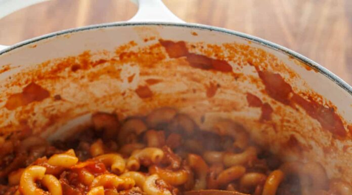 Dutch oven filled with American Goulash with ground beef, tomatoes and elbow macaroni pasta