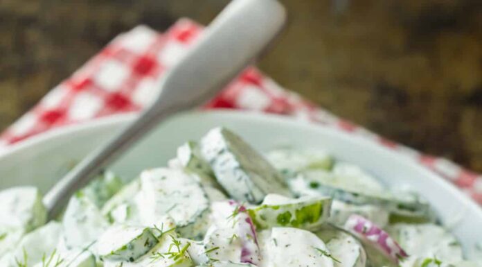 Creamy cucumber salad recipe in a serving bowl garnished with dill