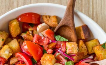 Panzanella Salad tossed in a bowl garnished with basil