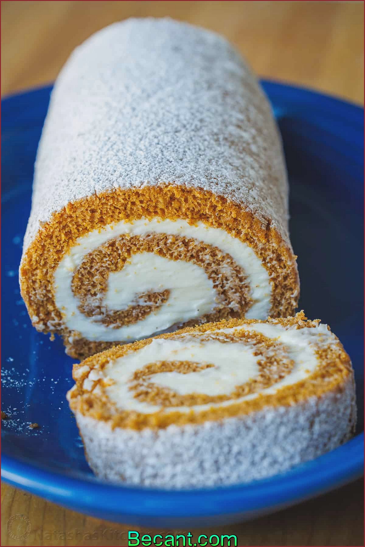 Gâteau roulé à la citrouille servi sur une assiette bleue et tranché